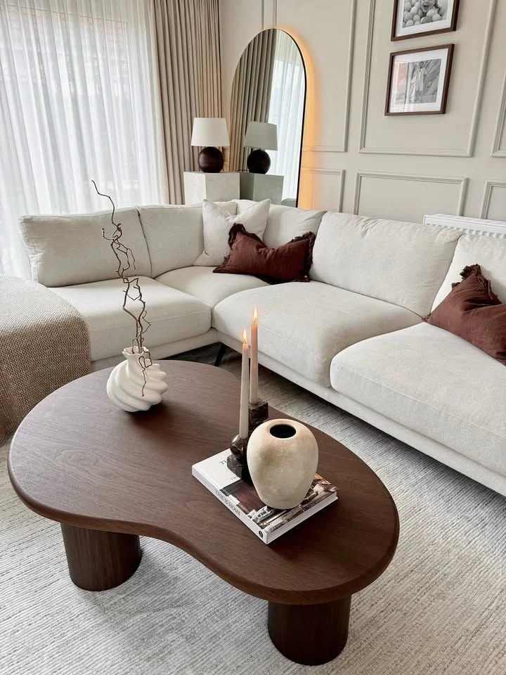Cream living room with white couches and a decorative mirror embodying serenity